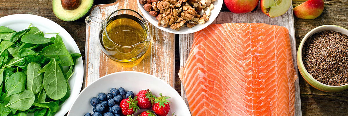 A display of healthy food options: vegetables, fruits and salmon.