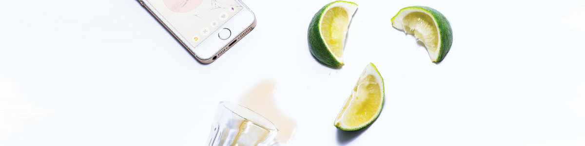 Photo of a smartphone, limes and a glass.