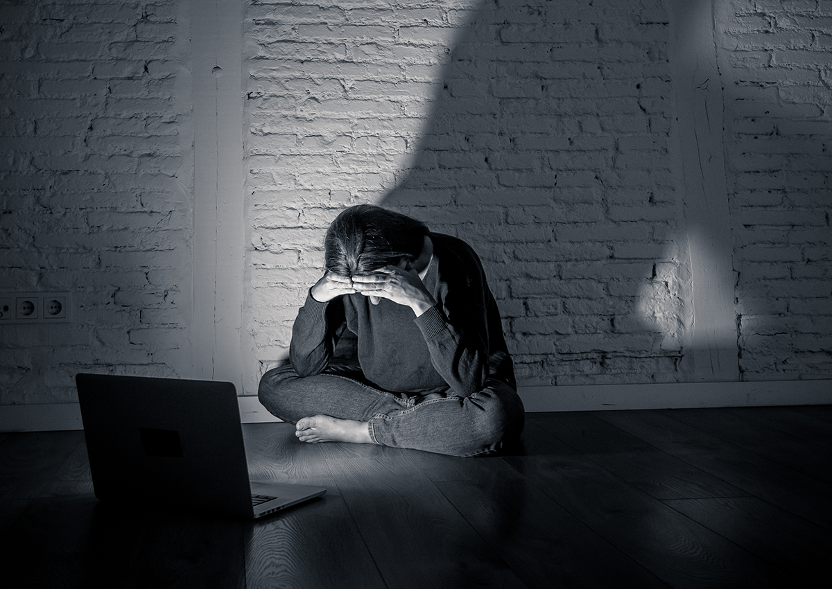 Sad and scared female young woman with computer laptop.