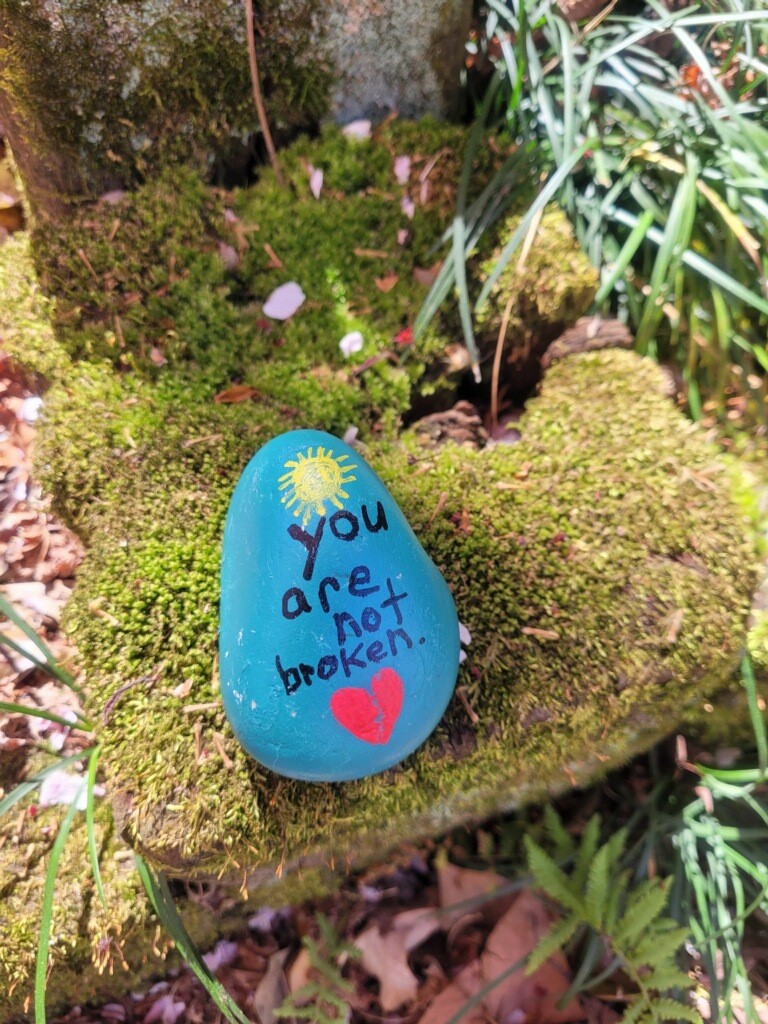 Rock painted with the words you are not broken.
